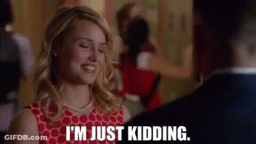 A Woman In A Red Dress Is Smiling And Talking To A Man In A Suit . GIF