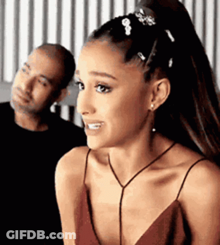 A Woman In A Red Dress Is Smiling While Standing Next To A Man . GIF
