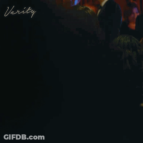 A Woman In A Red Dress Is Standing At A Bar With The Word Verity Written On The Bottom GIF