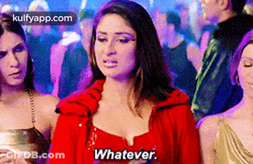 A Woman In A Red Dress Is Standing In A Crowd Of People And Saying Whatever . GIF
