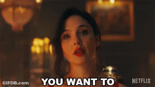 A Woman In A Red Dress Is Standing In A Dark Room And Says `` You Want To '' . GIF