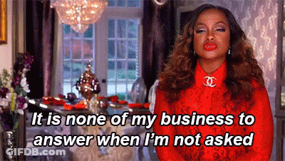 A Woman In A Red Dress Is Standing In A Living Room And Talking About Her Business . GIF
