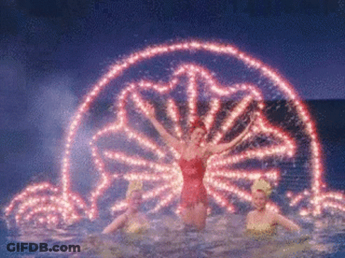 A Woman In A Red Dress Is Standing In A Pool Of Water GIF