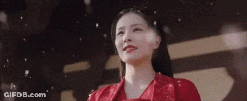 A Woman In A Red Dress Is Standing In Front Of A Black And White Background . GIF