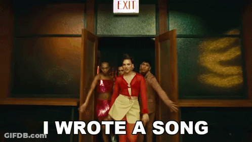 A Woman In A Red Dress Is Standing In Front Of An Exit Sign And Says I Wrote A Song GIF
