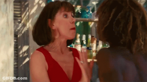 A Woman In A Red Dress Is Talking To Another Woman In A Bar GIF