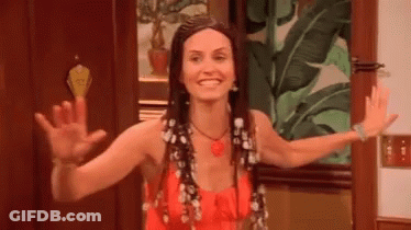 A Woman In A Red Dress Is Waving Her Hands In Front Of A Door . GIF