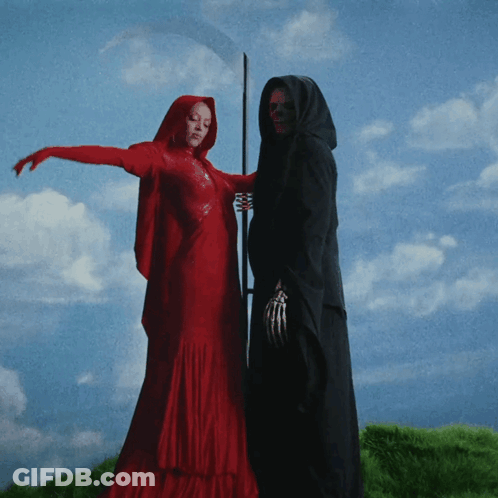 A Woman In A Red Dress Standing Next To A Grim Reaper GIF