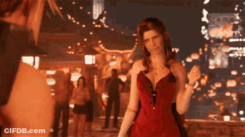 A Woman In A Red Dress Stands In Front Of A Crowd Of People GIF