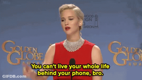 A Woman In A Red Dress Stands In Front Of A Microphone And Says You Can 'T Live Your Whole Life Behind Your Phone GIF
