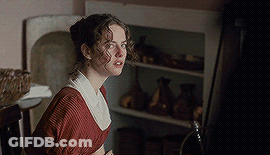 A Woman In A Red Dress Stands In Front Of A Shelf GIF