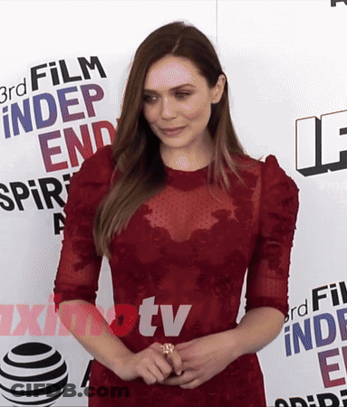 A Woman In A Red Dress Stands In Front Of A Sign That Says 3Rd Film Independent Spirit GIF