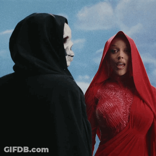 A Woman In A Red Dress Stands Next To A Grim Reaper In A Black Cape GIF