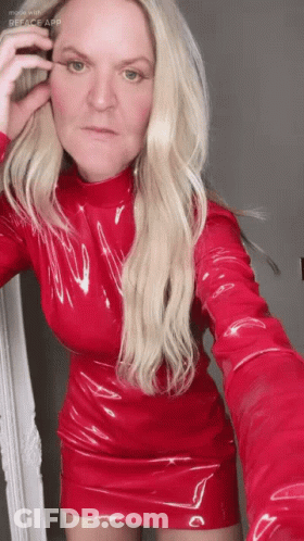 A Woman In A Red Dress Taking A Selfie With Reface App GIF