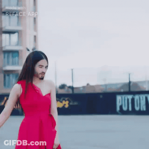 A Woman In A Red Dress With A Beard Is Standing In Front Of A Sign That Says Put On GIF