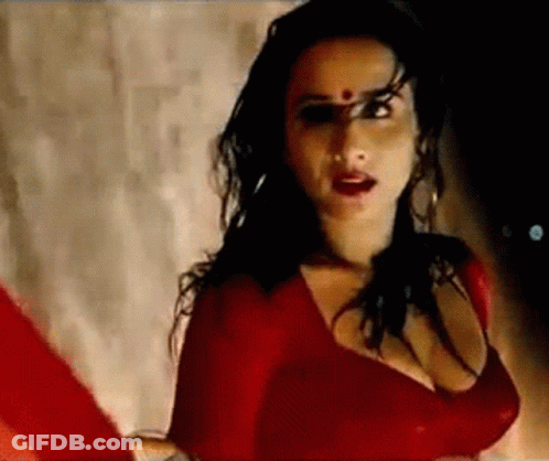A Woman In A Red Dress With A Red Dot On Her Forehead . GIF