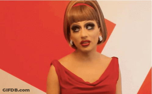 A Woman In A Red Dress With A Red Headband Is Making A Funny Face GIF