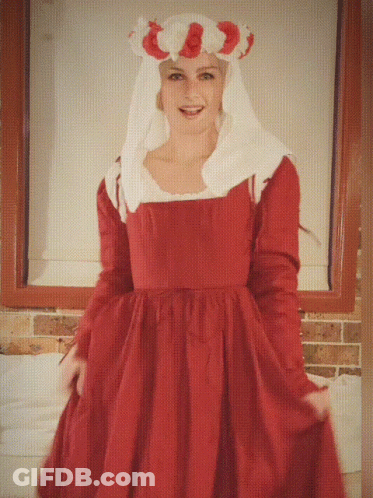 A Woman In A Red Dress With A White Veil Is Smiling GIF