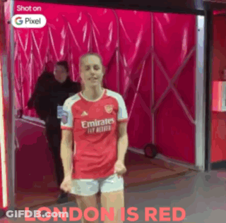 A Woman In A Red Emirates Jersey And Shorts Is Dancing GIF