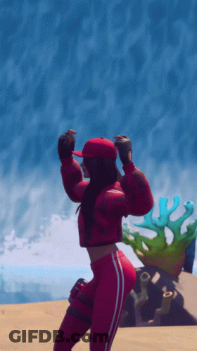 A Woman In A Red Jacket And Red Hat Is Dancing On The Beach GIF