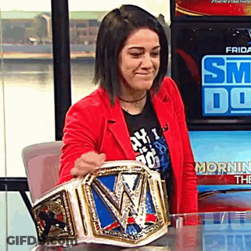 A Woman In A Red Jacket Holding A Wrestling Championship Belt GIF