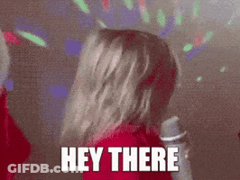 A Woman In A Red Jacket Is Singing Into A Microphone With The Words Hey There Above Her Head . GIF