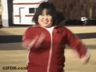 A Woman In A Red Jacket Is Smiling And Dancing . GIF
