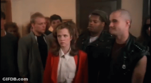 A Woman In A Red Jacket Is Surrounded By A Group Of People GIF