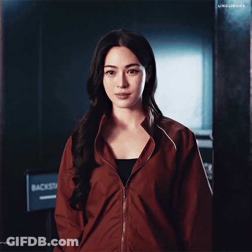 A Woman In A Red Jacket Is Taking A Picture Of Herself With Her Cell Phone GIF