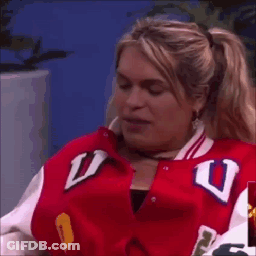 A Woman In A Red Jacket With The Letter U On It GIF