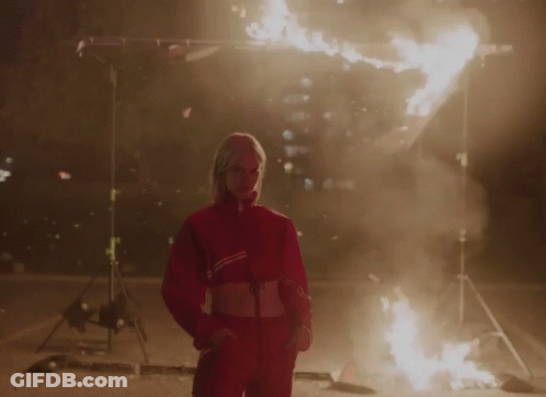 A Woman In A Red Jacket With The Word Adidas On It GIF