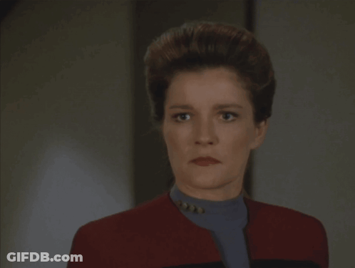 A Woman In A Red Jacket With The Word Coward Written On It GIF