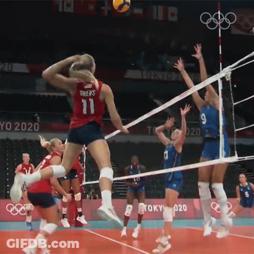 A Woman In A Red Jersey With The Number 11 Jumps To Block A Volleyball GIF
