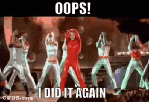 A Woman In A Red Jumpsuit Stands In Front Of A Group Of Dancers With The Caption Oops I Did It Again GIF