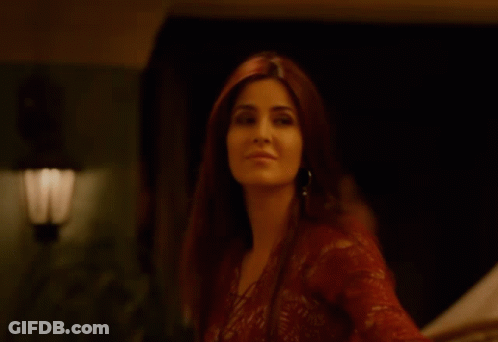A Woman In A Red Lace Top Is Smiling GIF