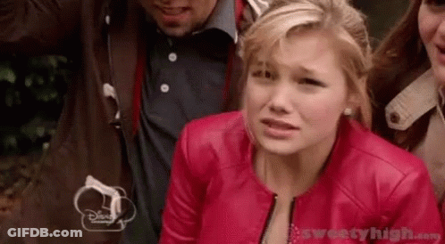 A Woman In A Red Leather Jacket Is Standing Next To A Group Of People . GIF