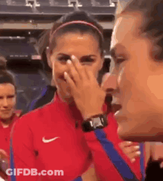 A Woman In A Red Nike Jacket Is Covering Her Face While A Man Looks On . GIF
