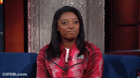 A Woman In A Red Nike Jacket Is Sitting On A Couch GIF
