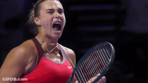 A Woman In A Red Nike Shirt Is Holding A Tennis Racket GIF