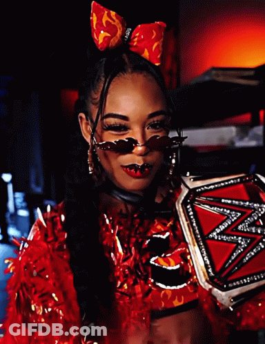 A Woman In A Red Outfit Is Holding A Wrestling Trophy GIF