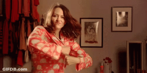 A Woman In A Red Pajamas Is Dancing In A Room GIF
