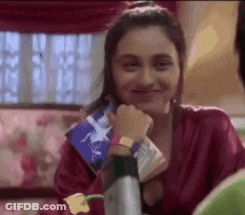 A Woman In A Red Robe Is Smiling While Holding A Piece Of Paper With A Star On It GIF
