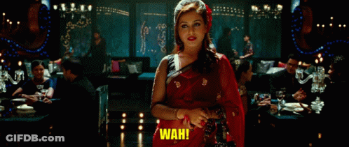 A Woman In A Red Sari Is Standing In A Room And Says Wah GIF