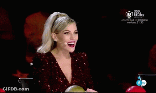 A Woman In A Red Sequined Dress Is Sitting In Front Of A Microphone With Her Hands In The Air . GIF