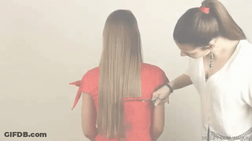 A Woman In A Red Shirt Is Getting Her Hair Cut By Another Woman GIF