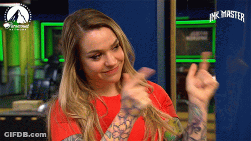 A Woman In A Red Shirt Is Giving A Thumbs Up In Front Of A Paramount Network Sign GIF