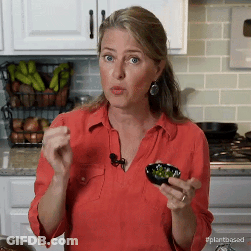 A Woman In A Red Shirt Is Holding A Bowl Of Vegetables In Her Hands GIF