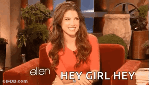 A Woman In A Red Shirt Is Sitting In A Chair And Smiling While Talking To Ellen Degeneres . GIF