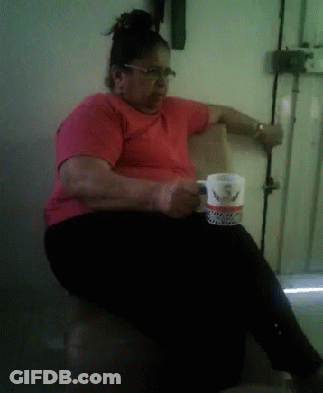 A Woman In A Red Shirt Is Sitting In A Chair Holding A Coffee Mug That Says ' I Love You ' On It GIF