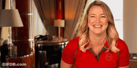 A Woman In A Red Shirt Is Smiling And Laughing In A Room . GIF